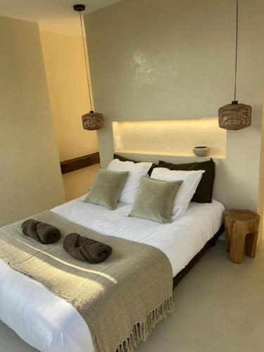 une chambre avec un lit avec deux serviettes dessus dans l'établissement Évasion balinaise, à Jouy-en-Josas