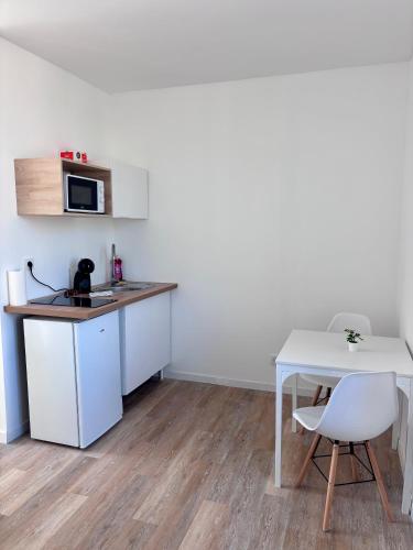 une petite cuisine avec une table et un micro-ondes dans l'établissement Studio Greenway, à Amiens