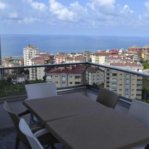 a table and chairs on a balcony with a view of a city at Shahin Golden Hotel الصقر الذهبي للشقق الفندقية in Bostancı