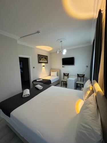 a bedroom with a large white bed and a living room at Ali's Pension ada alis in Egirdir