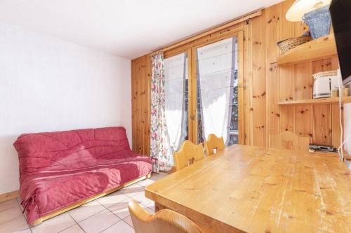 a living room with a couch and a wooden table at La Foret des Rennes - Les Saisies in Les Saisies