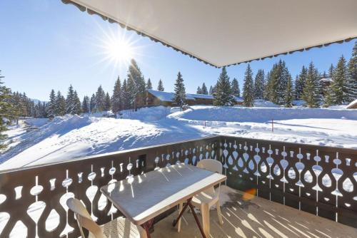 a table and chairs on a balcony with snow at La Foret des Rennes - Les Saisies in Les Saisies