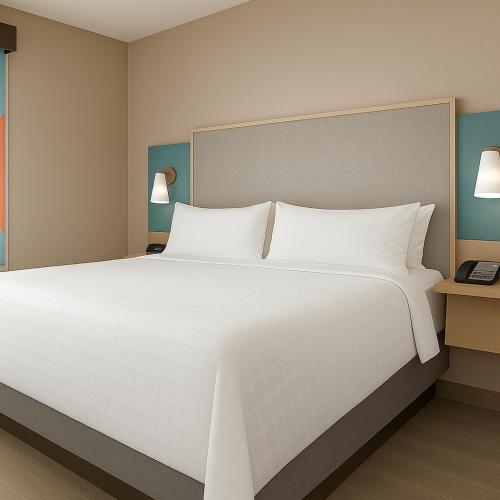 una camera da letto con un grande letto bianco con due lampade di avid hotel Fayetteville West a Fayetteville