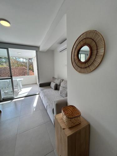 a living room with a couch and a mirror at Edificio Cerezo 77 by D&G in Carilo