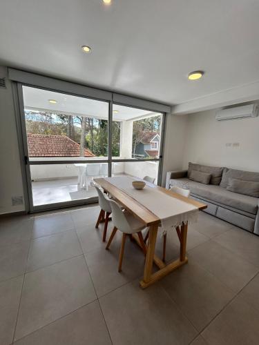 a living room with a wooden table and a couch at Edificio Cerezo 77 by D&G in Carilo