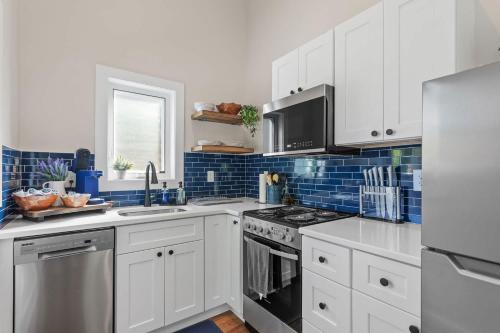 a kitchen with white cabinets and a stove top oven at The Raleigh Nook - near Lenovo Center & Fairground in Raleigh