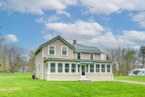 a house on a grassy field with a sky at Getaway in Sodus Point with Private Yard in Sodus