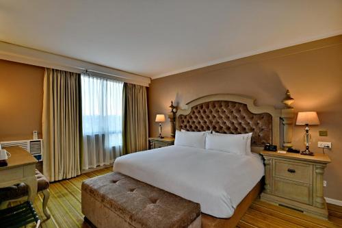 a bedroom with a large bed and a large window at Holiday Inn - Harare by IHG in Harare