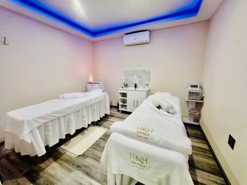 a hospital room with two beds with white blankets at H & H Boutique & SPA in Roodepoort