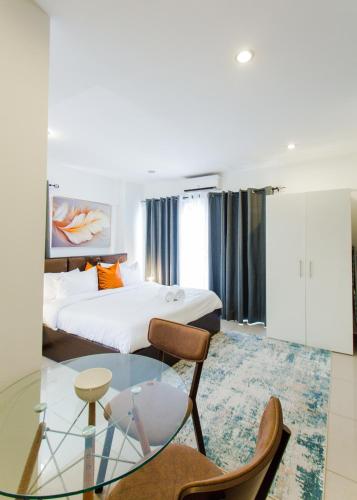 a hotel room with a bed and a glass table at Accra Luxury Apartments at The Gallery in Accra
