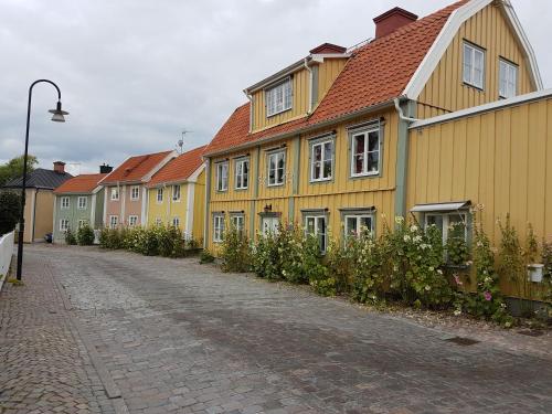 a row of yellow houses on a cobblestone street at Madickenhuset in Söderköping
