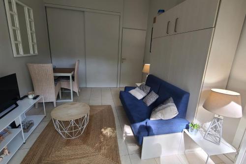 un salon avec un canapé bleu et une table dans l'établissement Nice studio with terrace near the beach, à Arcachon