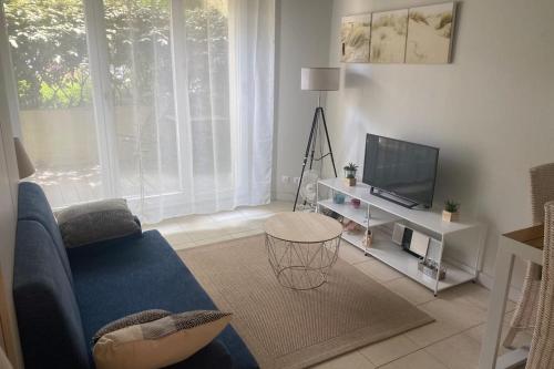 un salon avec un canapé bleu et une télévision dans l'établissement Nice studio with terrace near the beach, à Arcachon