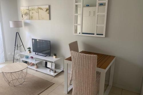 un salon avec une table et une télévision dans l'établissement Nice studio with terrace near the beach, à Arcachon