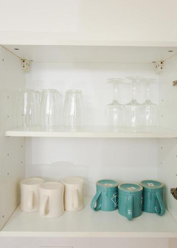 a row of glasses and bowls on shelves at Accra Luxury Apartments at The Gallery in Accra