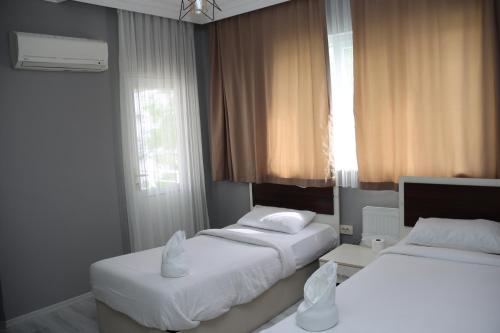 a bedroom with two beds and a window at Grand Koru Hotel Beach in Yalova