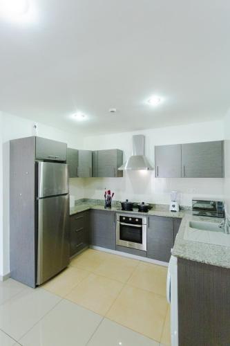 a large kitchen with stainless steel appliances and gray cabinets at Accra Luxury Apartments at The Gallery in Accra