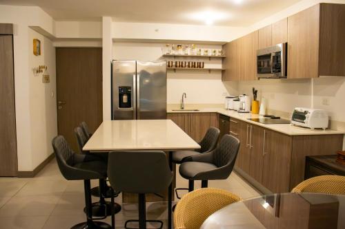 a kitchen with a table and chairs and a refrigerator at Punta Esmeralda by Punta Leona in Jacó