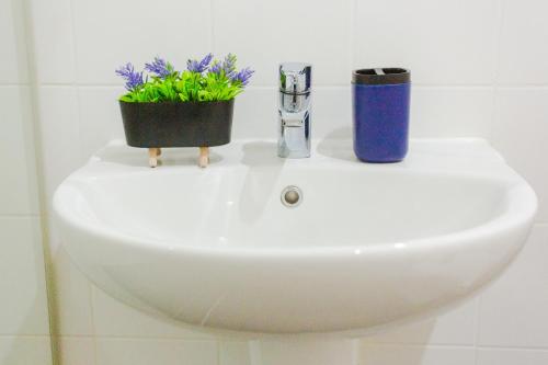 a white sink with a plant on top of it at Accra Luxury Apartments at The Gallery in Accra