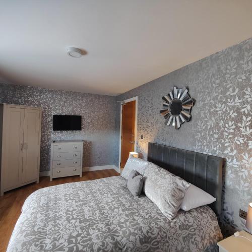 a bedroom with a large bed and a clock on the wall at Liverpool Stays - Kempston Court in Liverpool
