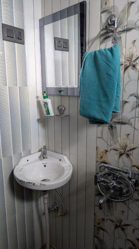 a bathroom with a sink and a mirror at Quarali Homestay in Mukteswar