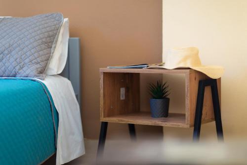 a nightstand next to a bed with a plant on it at Stefanias Prasoudi Beach in Ágios Matthaíos