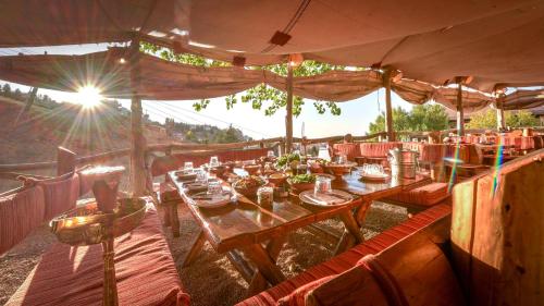 a restaurant with tables and chairs with the sun shining at InterContinental Mzaar Lebanon Mountain Resort & Spa by IHG in Kfardebian