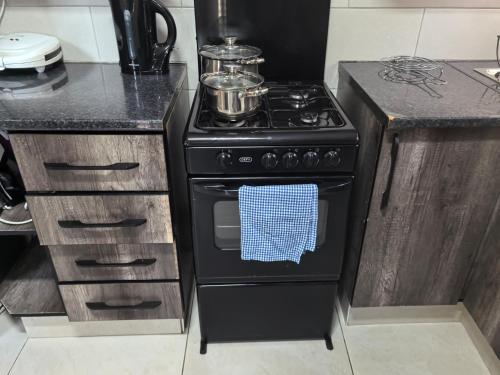 a kitchen with a black stove with a blue towel at SERENITY VILLA Self Catering Apartment in Gaborone