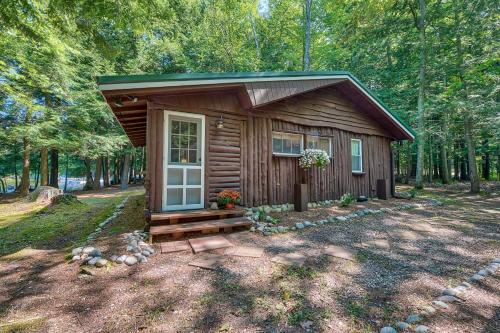 a small cabin in the middle of a forest at Steps to Lakefront Dog-Friendly Cabin in Levering in Pellston