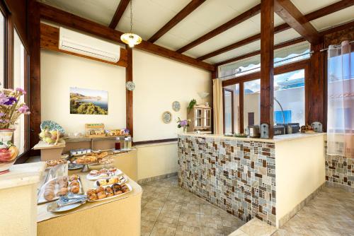 a large kitchen with a counter with doughnuts on it at Hotel La Darsena in San Vito lo Capo
