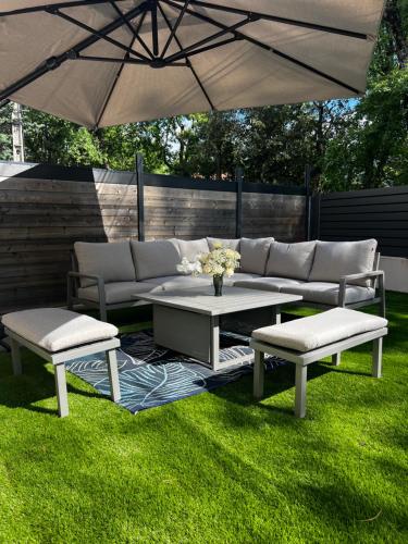 a patio with a table and two chairs and an umbrella at Maison la Cocagne de la Sainte Baume in Nans-les-Pins
