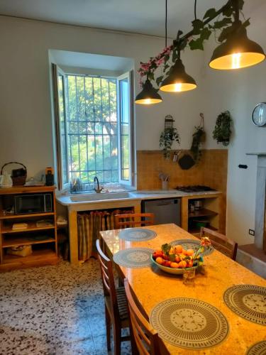 a kitchen with a table with a bowl of fruit on it at casa vacanze La Versilia in Vallecchia