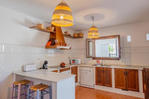 a kitchen with a counter and two stools at Casa El Tomillo in San José