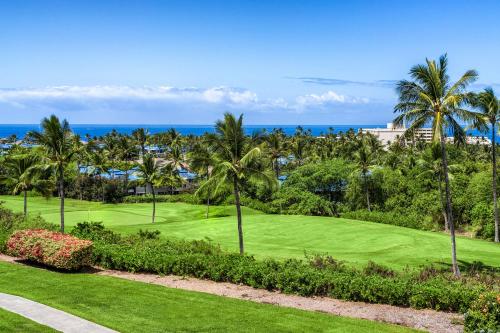 a golf course with palm trees and the ocean at Big Island Keauhou Punahele A301 by Coldwell Banker Island Vacations in Kailua-Kona