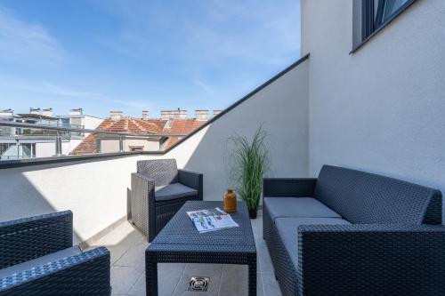 a balcony with chairs and a table with a book on it at Vienna Stay Apartments Schönbrunn in Vienna