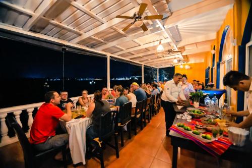 a group of people sitting at tables in a restaurant at Hotel Villa del Lago in Flores