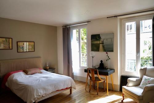 a bedroom with a bed and a desk and a chair at Country house in Paris in Boulogne-Billancourt