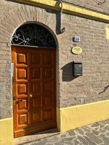 基亚拉瓦莱Affittacamere Il Cortile的砖砌建筑上的木门,上面有标志