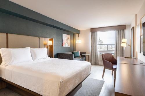 a hotel room with a bed and a desk and a chair at Holiday Inn & Suites Winnipeg Downtown by IHG in Winnipeg