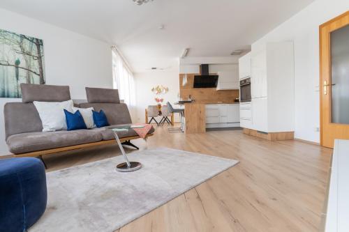 a living room with a couch and a kitchen at Apartment Klagenfurt Center with Free Parking - RING41 in Klagenfurt