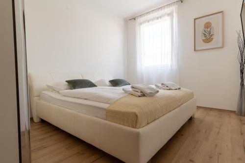 a bed in a white room with a mirror at Apartment Klagenfurt Center with Free Parking - RING41 in Klagenfurt