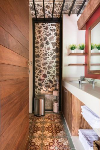 a bathroom with a stone wall and a sink at CASA SAUTO SUITE CON BALCON in Mexico City