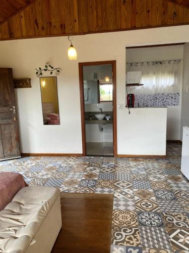 a living room with a couch and a bathroom at Chalé Aconchego da Paz - Chalé 2 in Lavras Novas