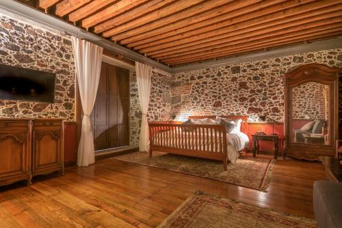 a bedroom with a bed in a stone wall at CASA SAUTO SUITE CON BALCON in Mexico City