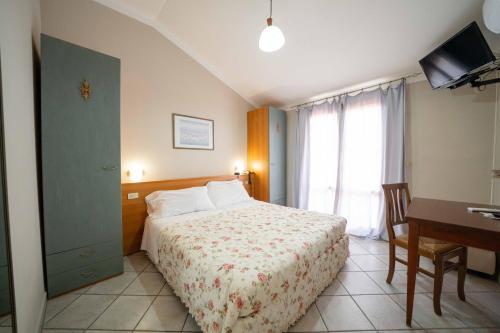 a hotel room with a bed and a desk and a window at Bellavista Hotel & Osteria in Lamporecchio