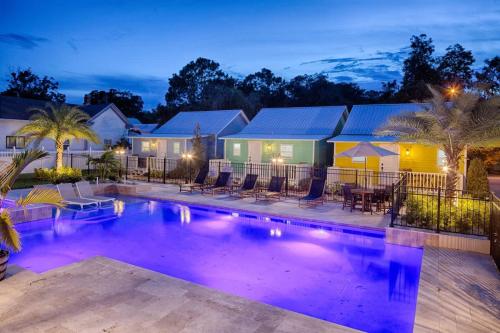 a swimming pool at night with chairs and tables at Quaint Cottage with Private Pool-Walk to Everything in St. Augustine