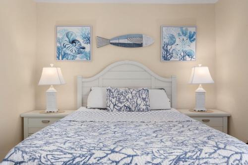a bedroom with a white bed with two lamps at QA4 Coastal Comfort in Nags Head