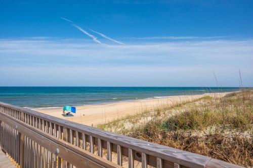a view of a beach with an umbrella and the ocean at QA4 Coastal Comfort in Nags Head