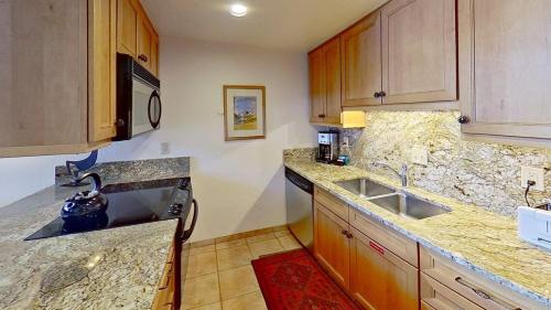 a kitchen with wooden cabinets and a sink at Crestwood 3310 Standard 1 Bedroom Plus Loft in Snowmass Village