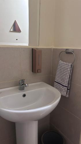 a bathroom with a white sink and a mirror at Regal Suites in Athi River